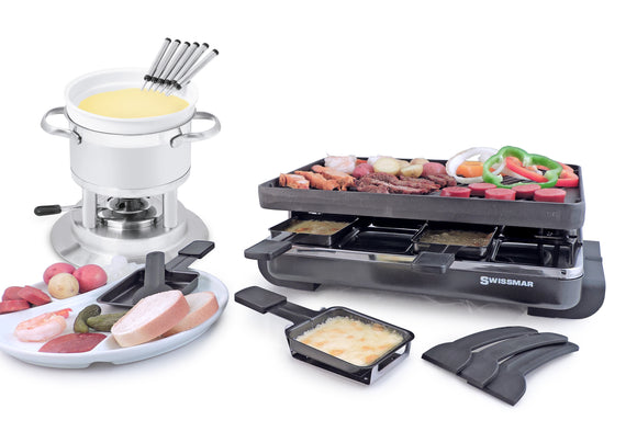 Fondue with cheese and raclette with food on top. There is a plate in front with food on it as well